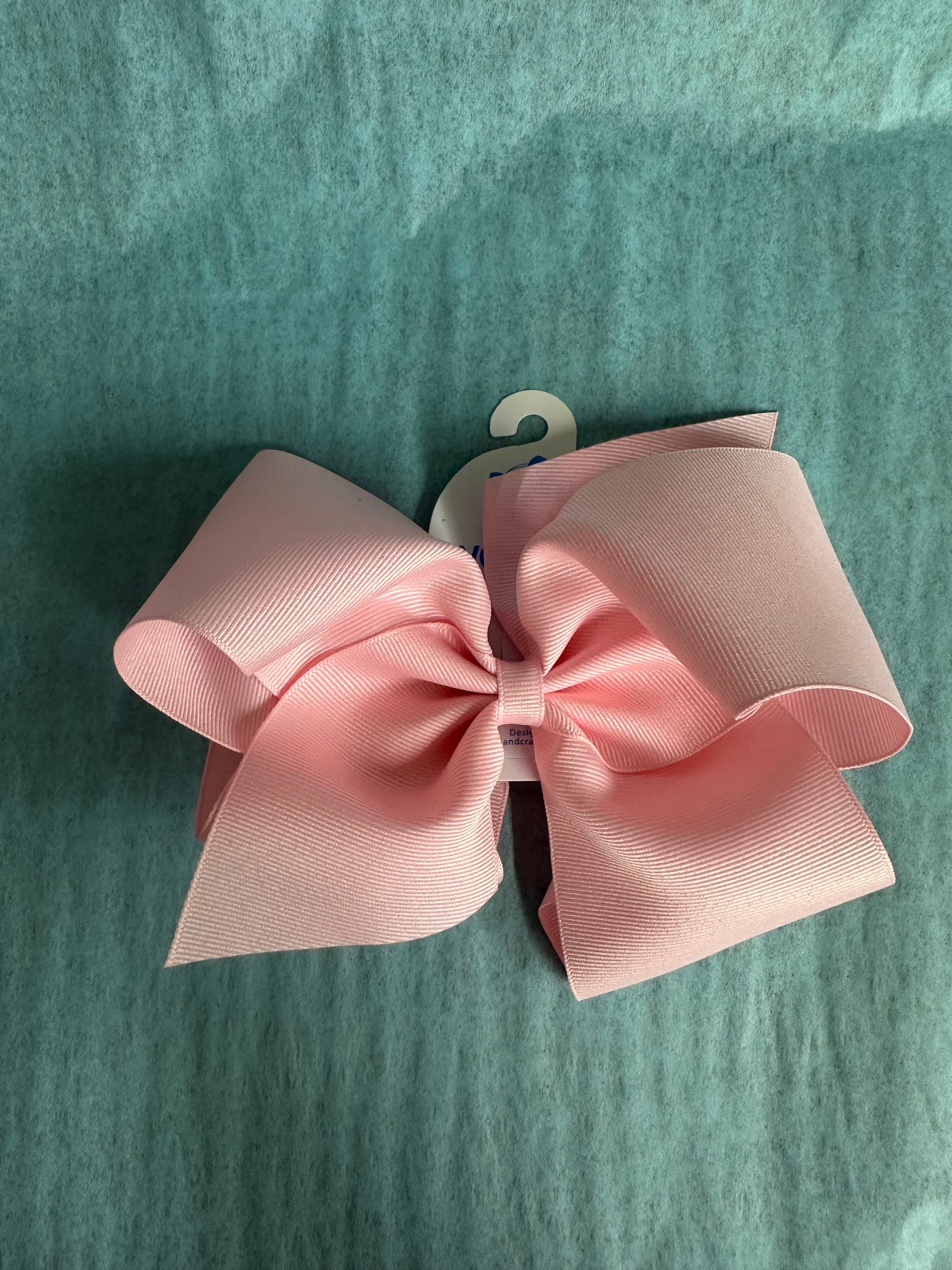Pink hair bow on a green textured background
