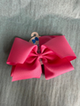 Large pink bow with a wooden hook on a gray surface