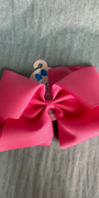 Large pink bow with a wooden hook on a gray surface