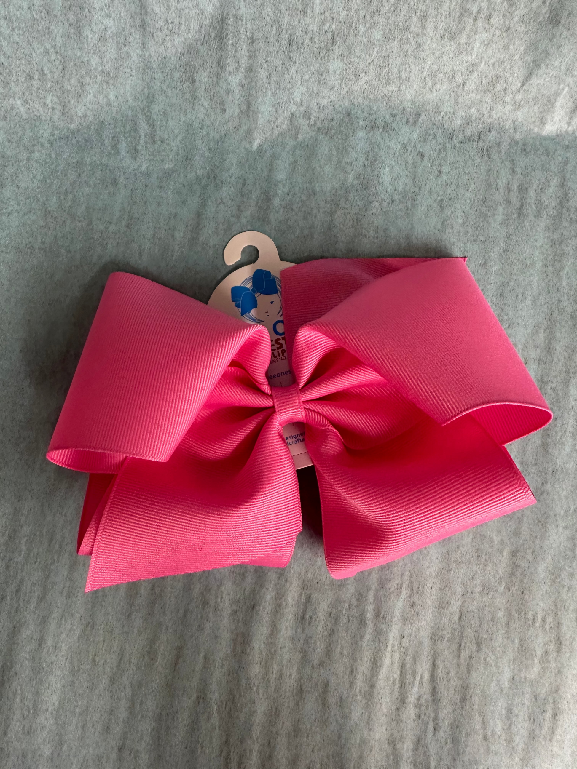 Large pink bow with a wooden hook on a gray surface