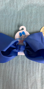 Blue hair bow with a tag on a gray background