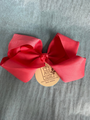 Coral bow with a brand tag on a gray background