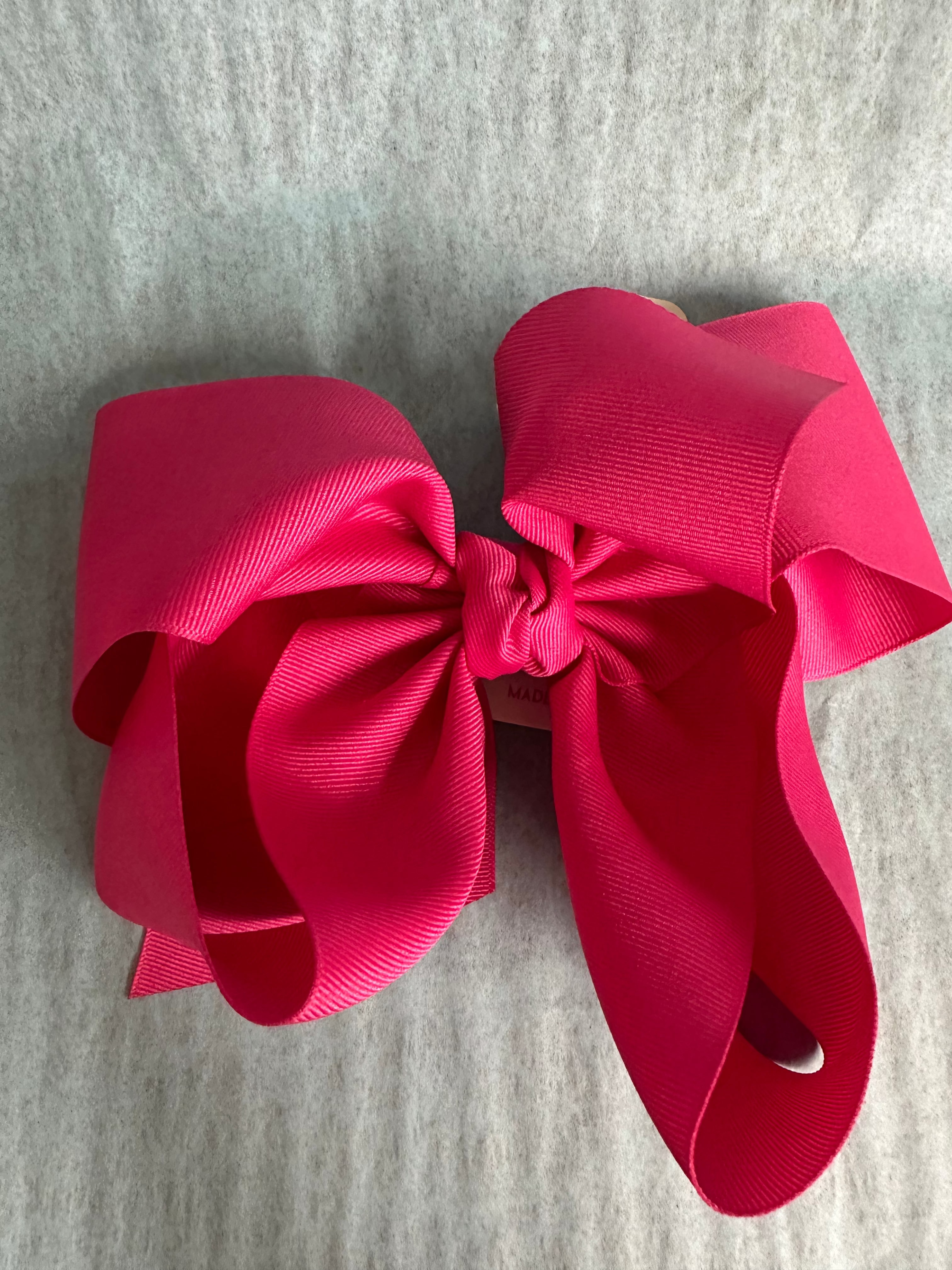 Large pink bow on a gray fabric background