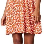 Woman wearing a floral dress with ruffled sleeves against a neutral background