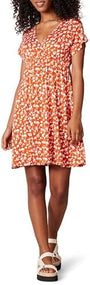 Woman wearing a floral dress with ruffled sleeves against a neutral background