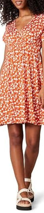 Woman wearing a floral dress with ruffled sleeves against a neutral background