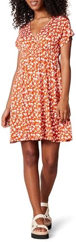 Woman wearing a floral dress with ruffled sleeves against a neutral background