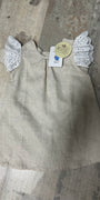 Beige dress with angel wings on a textured surface