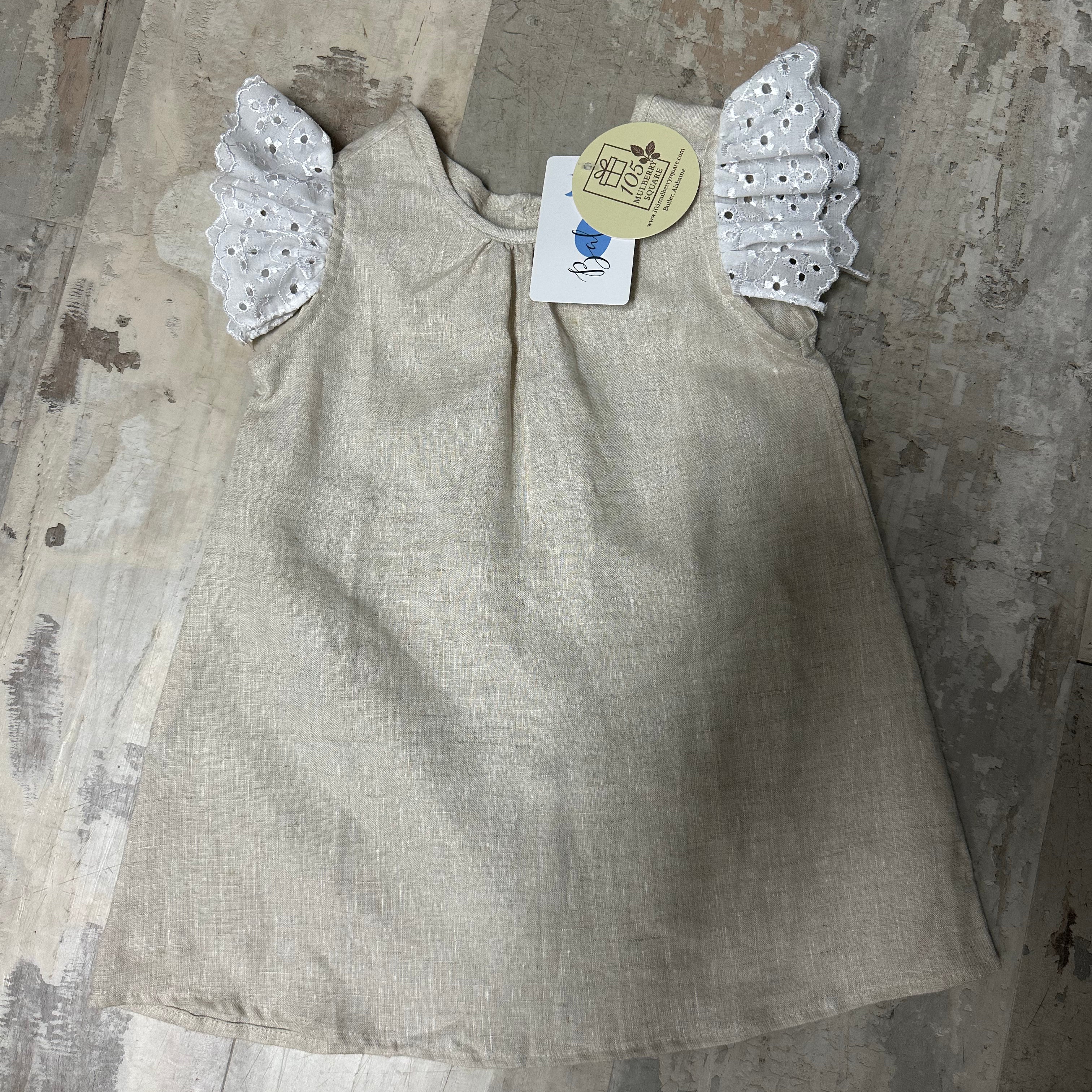 Beige dress with angel wings on a textured surface