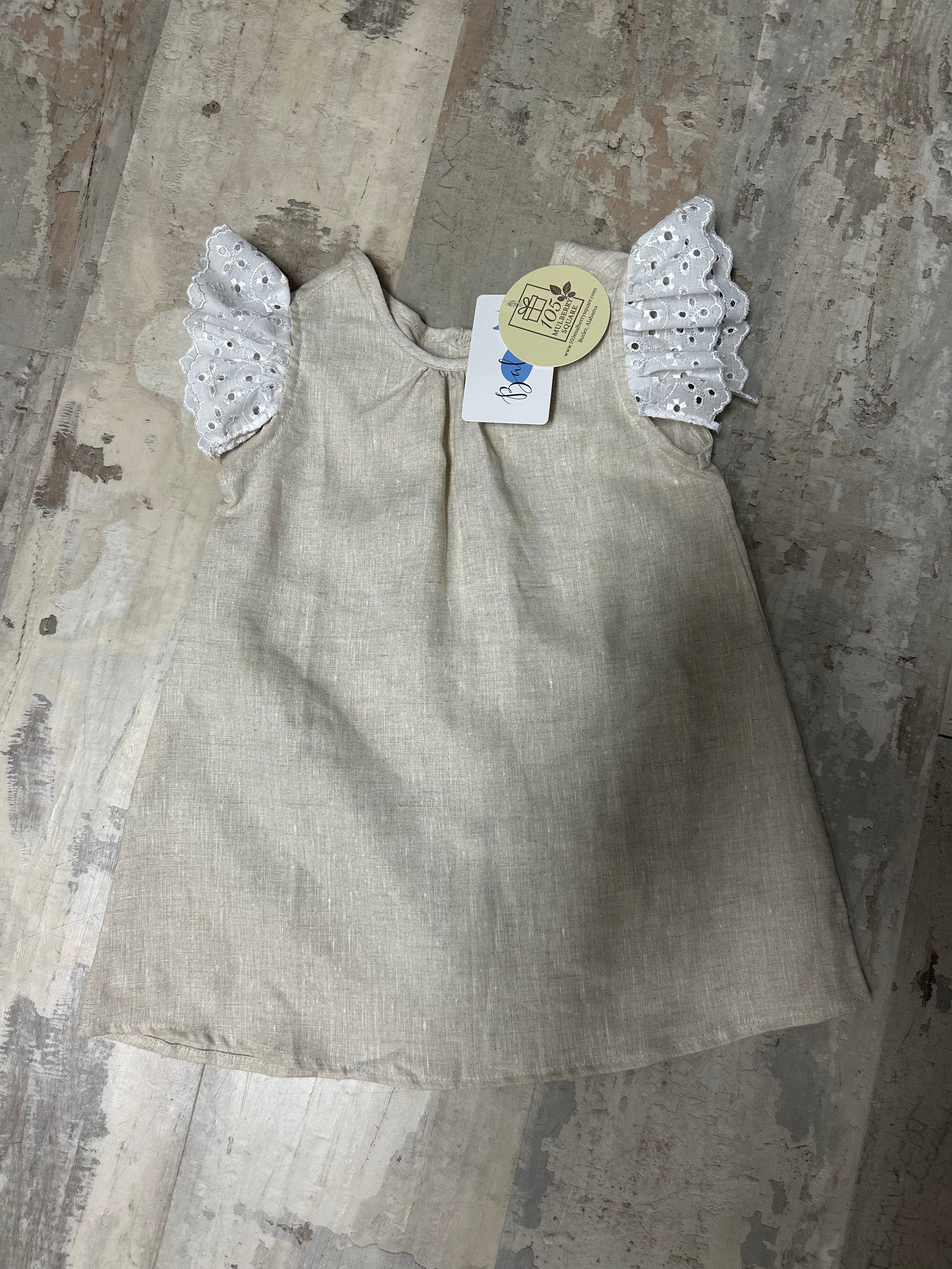 Beige dress with angel wings on a textured surface