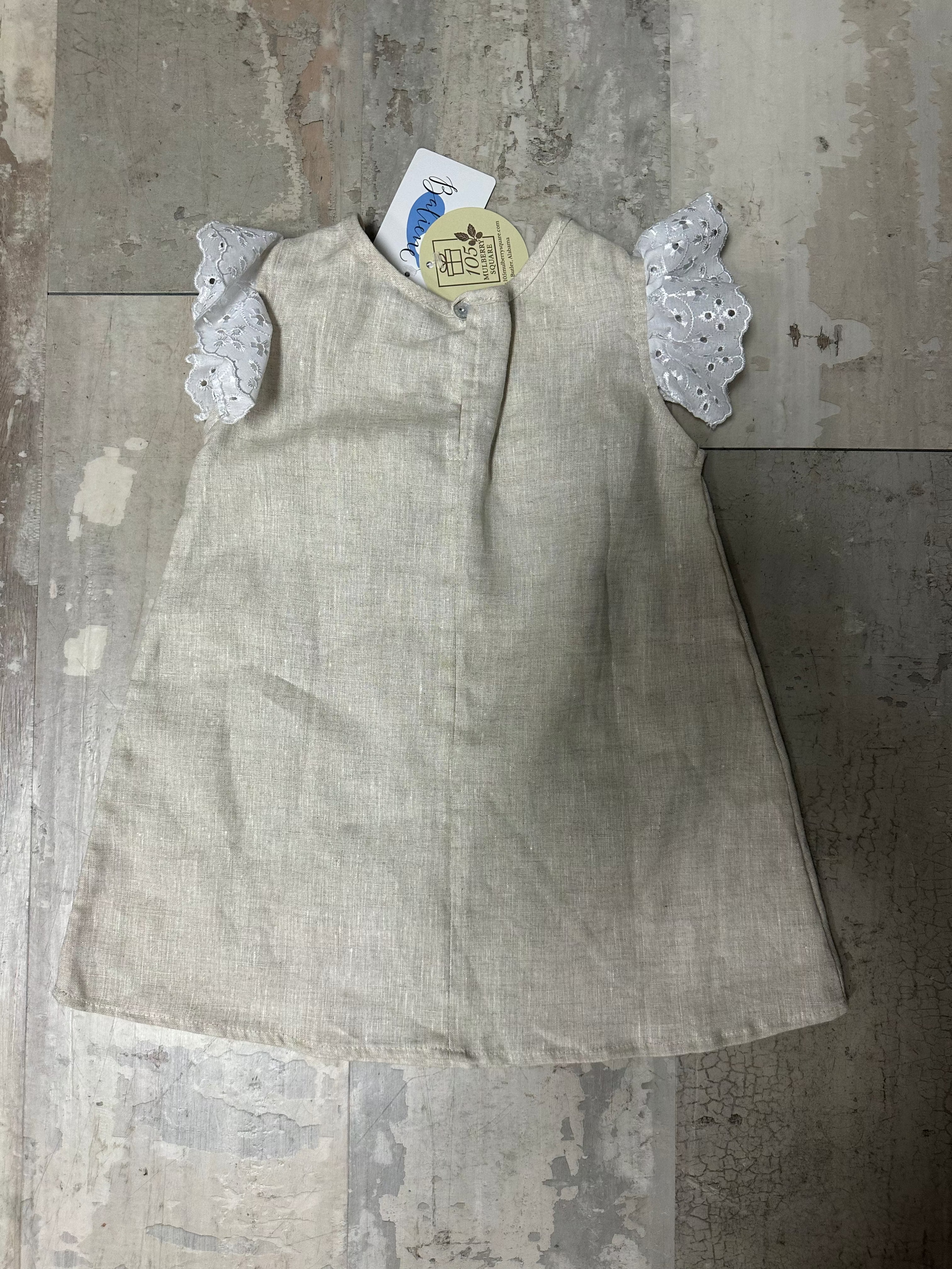 Light-colored fabric item with lace trim on a textured stone surface