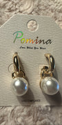 Large pearl dangle earrings on a white fluffy background