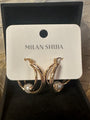 Gold crescent hoop earrings with a small white pearl, displayed on a white card labeled 'MILAN SHIJIA' inside a black jewelry box.