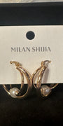 Gold crescent hoop earrings with a small white pearl, displayed on a white card labeled 'MILAN SHIJIA' inside a black jewelry box.