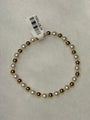 A beaded stretch bracelet featuring alternating white faux pearls and polished gold-toned beads, with a white paper tag attached.