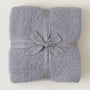 Folded gray blanket with a ribbon and 'Barefoot Dreams' branding on a white background