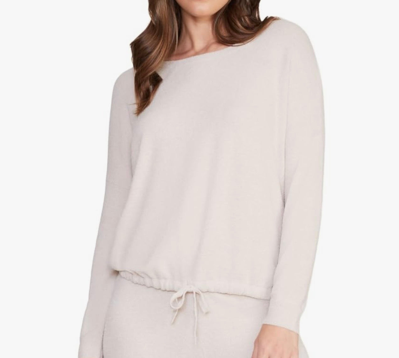 Woman wearing a cream  long-sleeve top on a white background