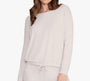 Woman wearing a cream  long-sleeve top on a white background