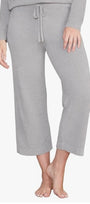 Person wearing gray pajama pants on a white background