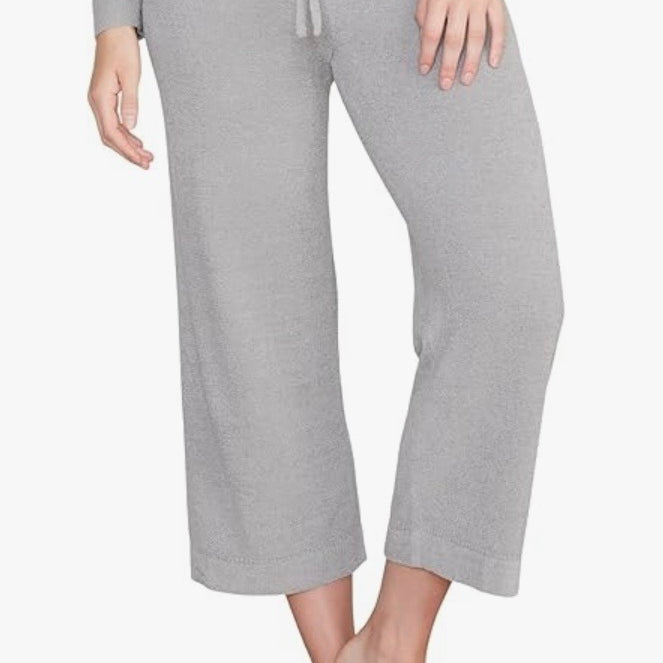 Person wearing gray pajama pants on a white background