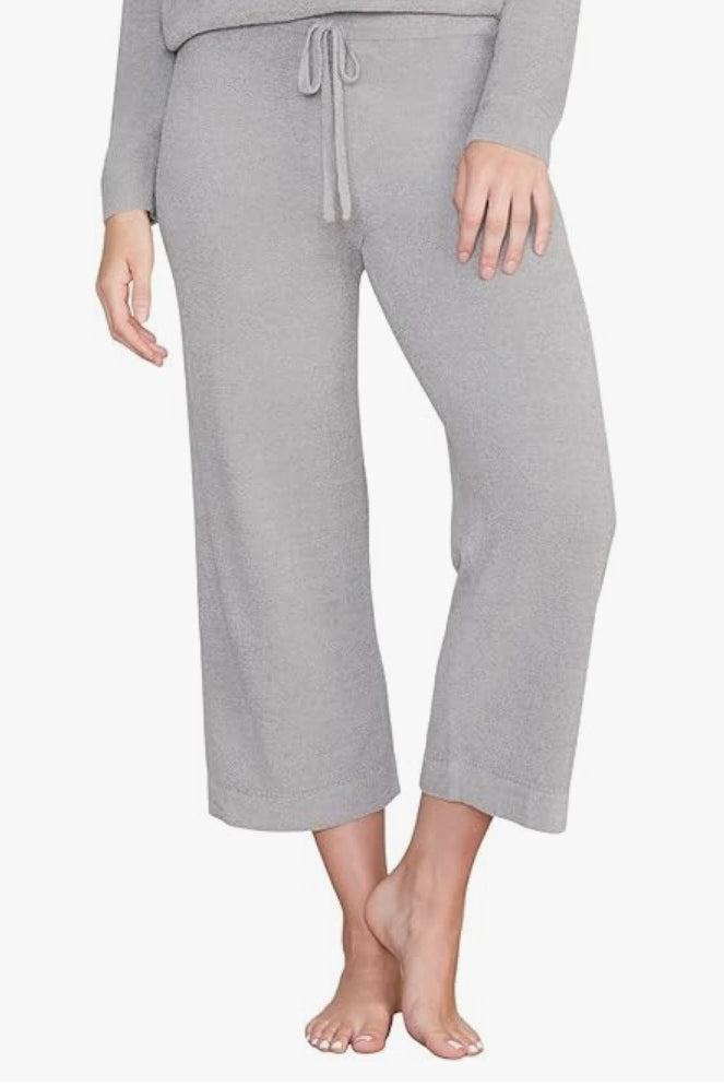 Person wearing gray pajama pants on a white background
