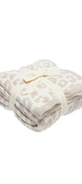 Folded blanket with a subtle pattern on a white background