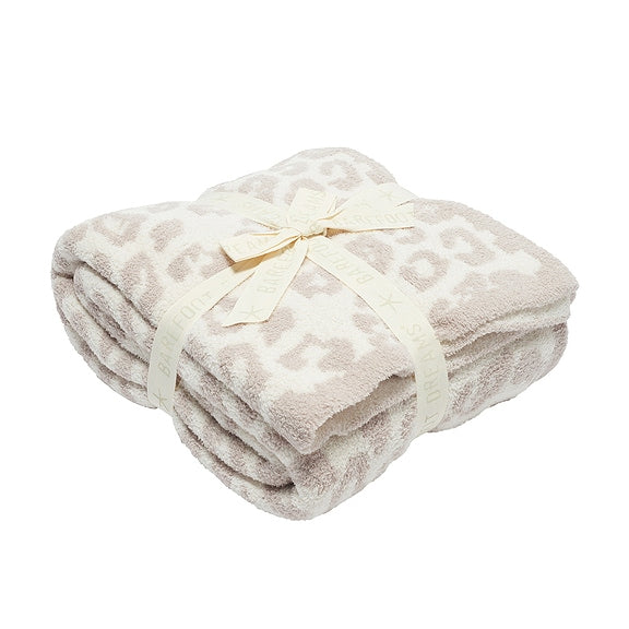 Folded blanket with a subtle pattern on a white background
