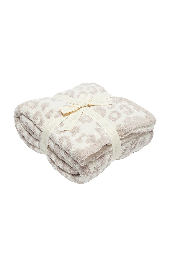 Folded blanket with a subtle pattern on a white background