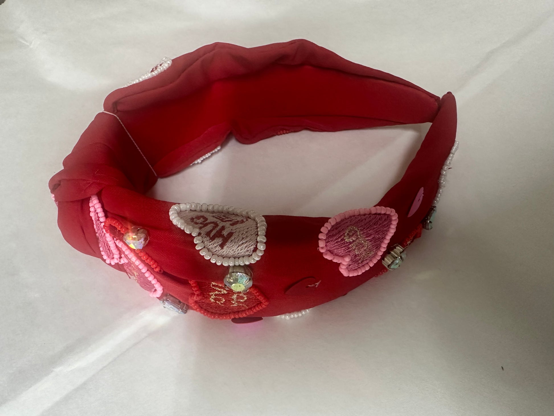 Red headband with decorative elements on a white background