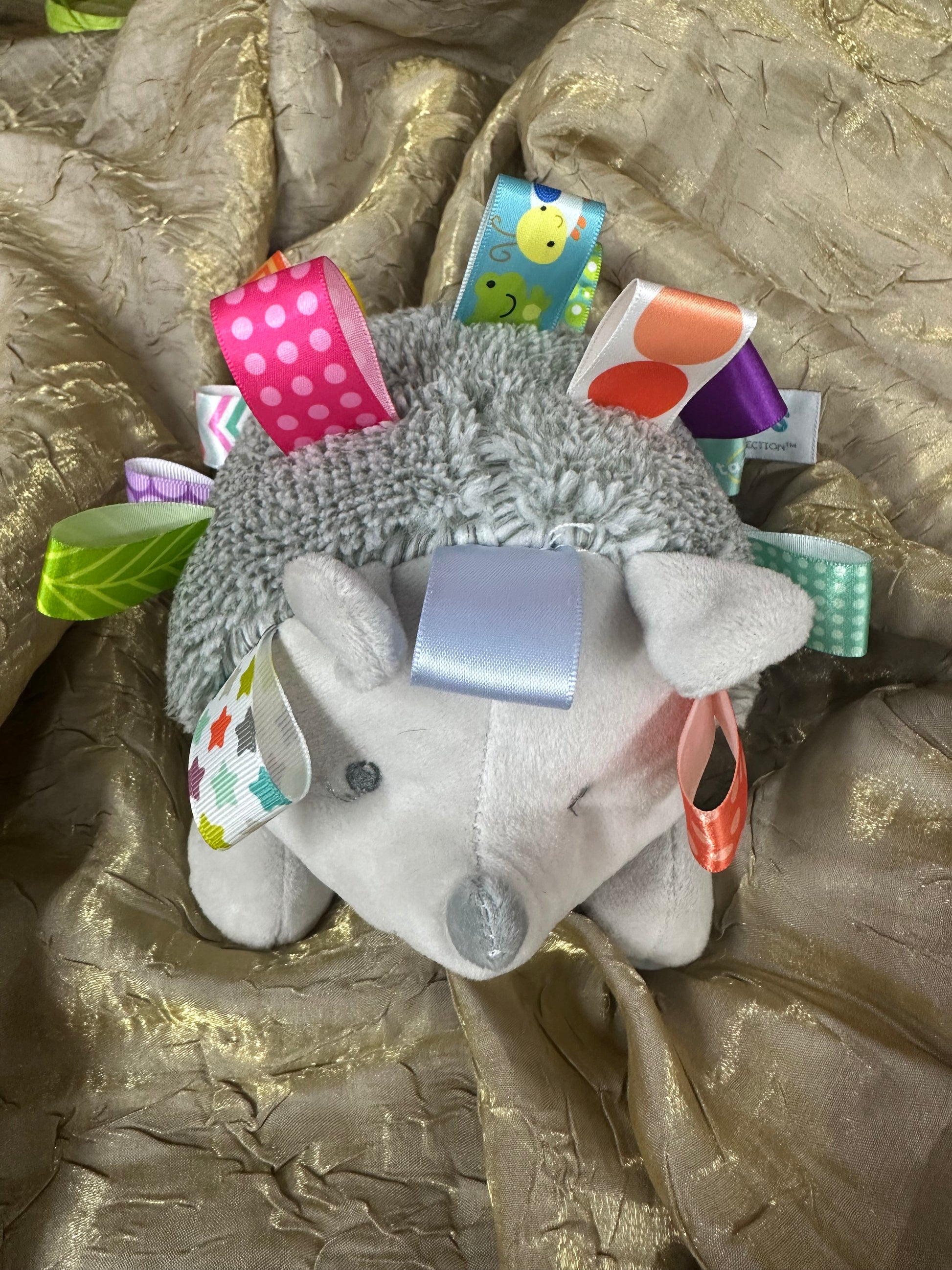 Plush toy with colorful tags on a textured surface