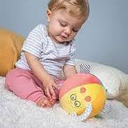 Baby playing with a soft toy on a light blue background