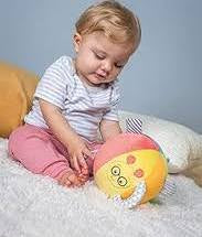 Baby playing with a soft toy on a light blue background