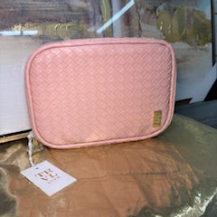 Pink pouch with a tag on a reflective surface