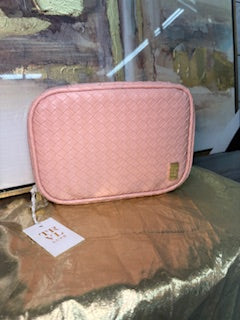 Pink pouch with a tag on a reflective surface