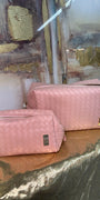 Pink quilted bags on a reflective surface