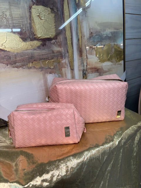 Pink quilted bags on a reflective surface