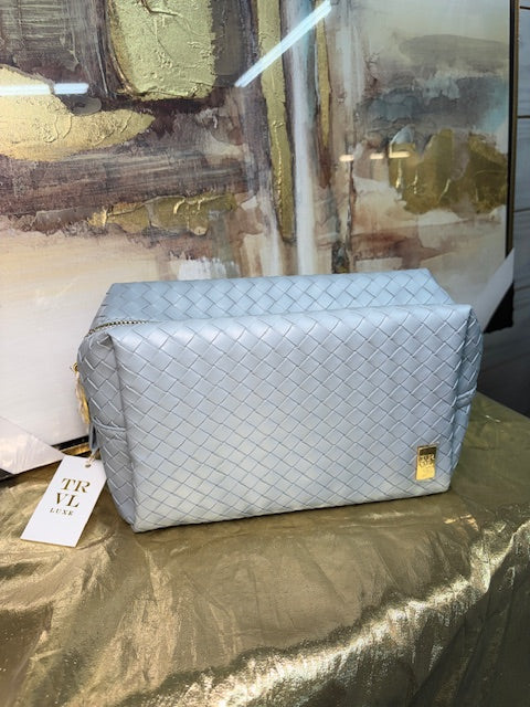 Light blue handbag with a visible brand tag on a reflective surface