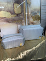 Two textured gray bags on a textured surface with a blurred background