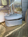 Gray quilted handbag on a textured surface with abstract art in the background