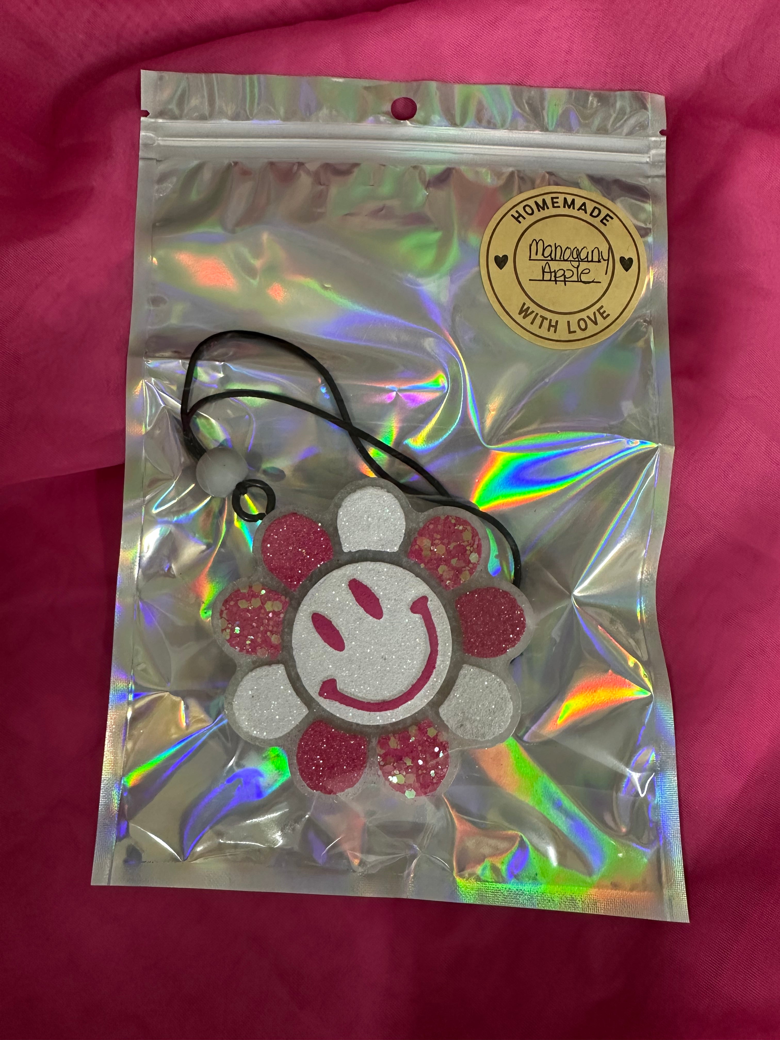 Holographic bag with a decorative item on a pink background