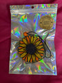 Holographic bag with a sunflower-shaped product on a pink background