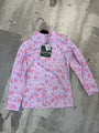 Pink patterned shirt with a brand tag on a concrete floor