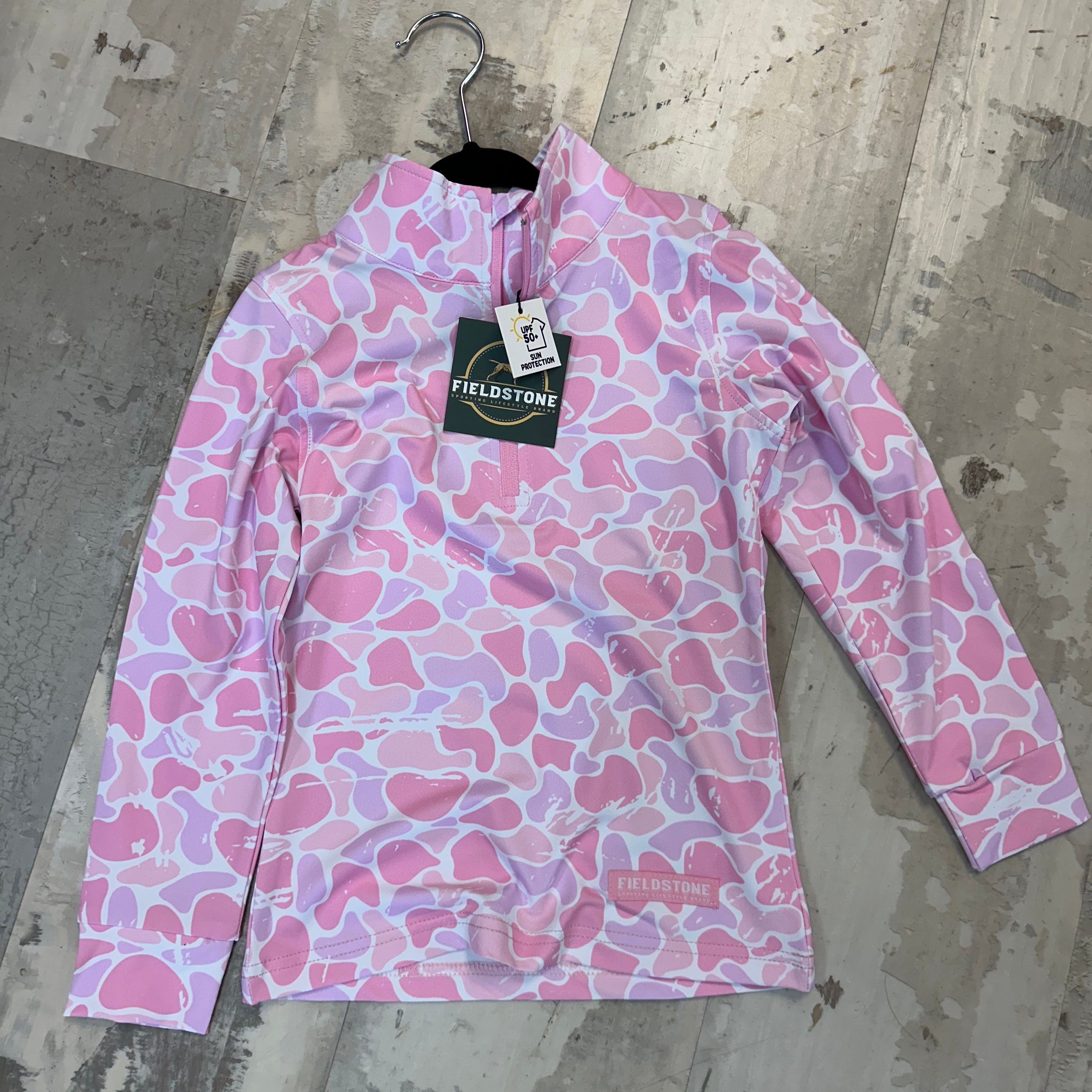 Pink patterned shirt with a brand tag on a concrete floor