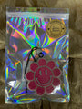 Holographic pouch with a pink glittery design on a textured brown background