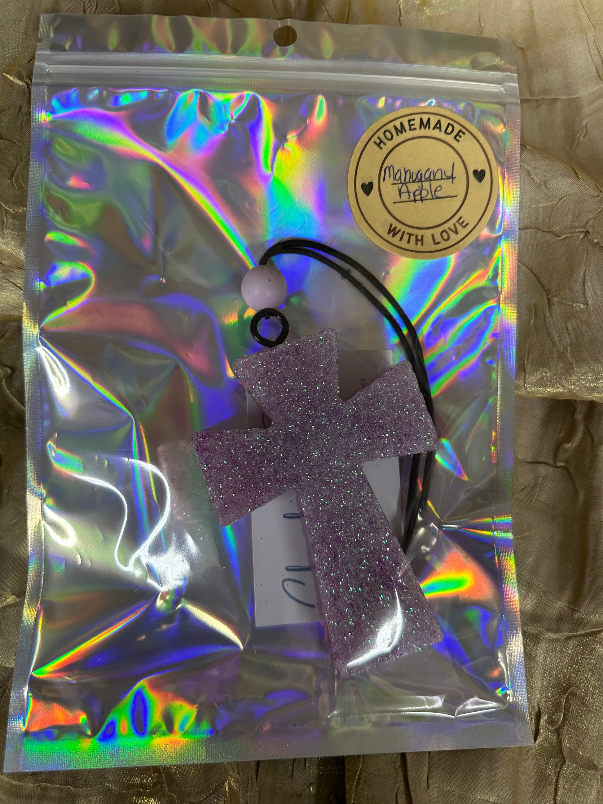 Purple glitter hair tie in a holographic packaging with 'Handmade' label.