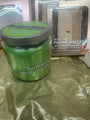 Green jar with a silver lid on a reflective surface