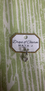 Heart charm in white gold on a textured green background 