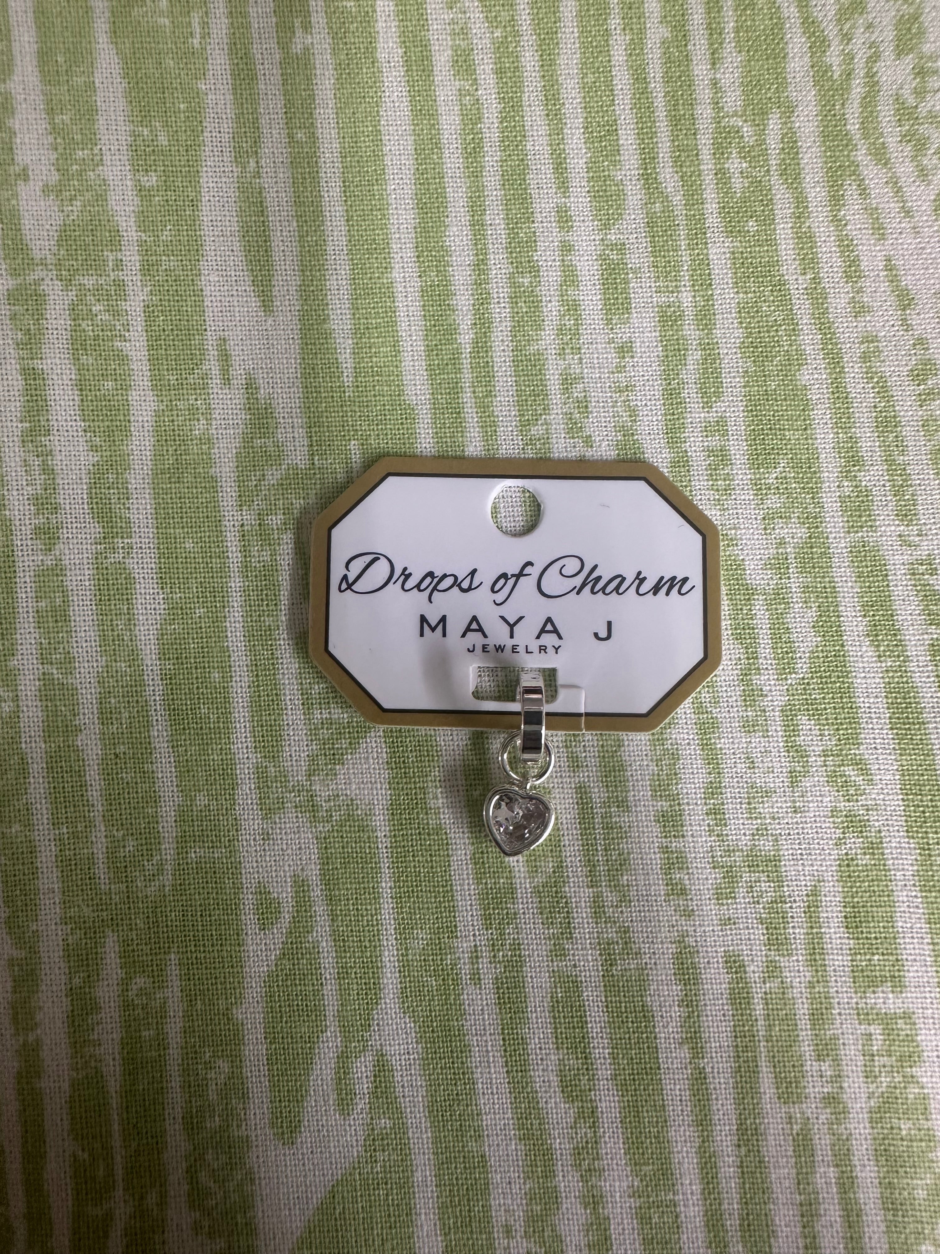 Heart charm in white gold on a textured green background 