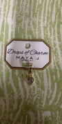 Yellow gold heart charm from Maya J called Drops of Charm on a green and white background