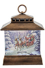 A decorative lantern-shaped Christmas ornament featuring a winter scene with Santa Claus in a sleigh pulled by reindeer, set against a snowy forest. The lantern has a rustic bronze-brown wood-grain frame and a top hanging loop, shown on a plain white background.